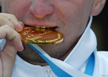 Russia's Yury Kudinov bites into his golden medal at the victory
ceremony after he won the men's 25 km Open Water race during the
European Swimming Championships in lake Templin in Potsdam, south of
the German capital Berlin on July 26, 2002. Russia's Yury Kudinov
clocked the fastest time in five hours nine minutes and 45 seconds
ahead of second placed Gilles Rondy of France and third placed David
Meca. REUTERS/Fabrizio Bensch
FAB/cmc