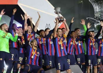 Barcelona's players celebrate on the podium after winning the Spanish Super Cup final football match between Real Madrid CF and FC Barcelona at the King Fahd International Stadium in Riyadh, Saudi Arabia, on January 15, 2023. (Photo by Giuseppe CACACE / AFP)