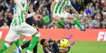 Real Betis' Mexican midfielder #18 Andres Guardado jumps over Real Madrid's Brazilian forward #11 Rodrygo during the Spanish league football match between Real Betis and Real Madrid CF at the Benito Villamarin stadium in Seville on December 9, 2023. (Photo by CRISTINA QUICLER / AFP)