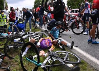Team B&B KTM's Bryan Coquard of France (R) and a Team Alpecin Fenix' rider lie on the ground after crashing during the 1st stage of the 108th edition of the Tour de France cycling race, 197 km between Brest and Landerneau, on June 26, 2021. (Photo by Anne-Christine POUJOULAT / various sources / AFP)