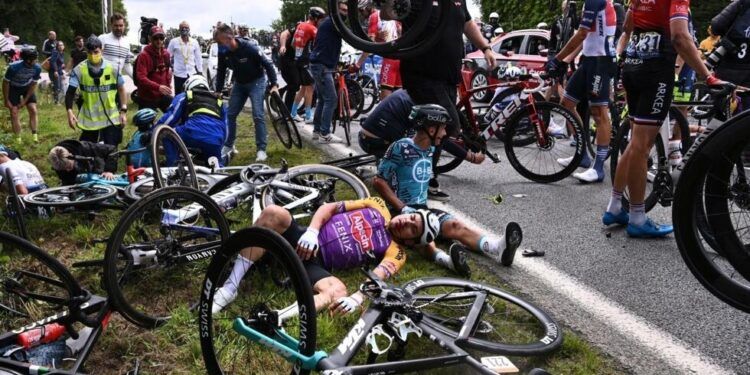 Team B&B KTM's Bryan Coquard of France (R) and a Team Alpecin Fenix' rider lie on the ground after crashing during the 1st stage of the 108th edition of the Tour de France cycling race, 197 km between Brest and Landerneau, on June 26, 2021. (Photo by Anne-Christine POUJOULAT / various sources / AFP)