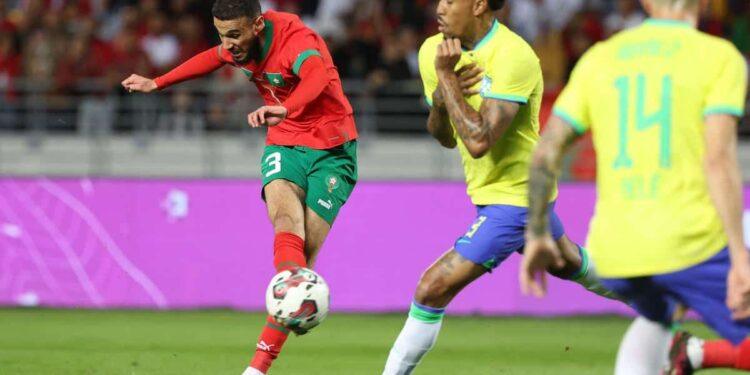 Morocco's defender Noussair Mazraoui (L) attempts a shot during a friendly football match between Morocco and Brazil at the Ibn Batouta Stadium in Tangier on March 26, 2023. (Photo by Fadel Senna / AFP)