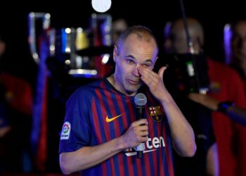 Barcelona's Spanish midfielder Andres Iniesta wipes his tears as he addresses fans during a tribute after the Spanish league football match between FC Barcelona and Real Sociedad at the Camp Nou stadium in Barcelona on May 20, 2018. Iniesta, who joined Barcelona's academy 22 years ago, played his final game for the club. / AFP / LLUIS GENE